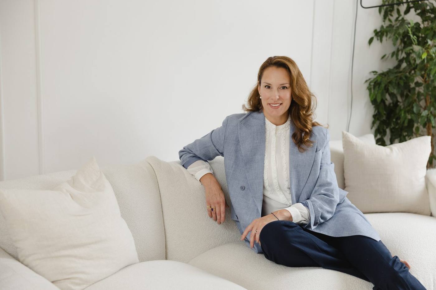 Anastasia Roumelioti seated, in a light blue blazer