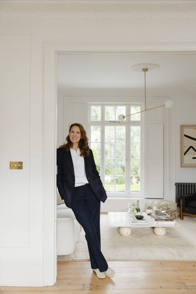 Anastasia Roumelioti in a navy suit, standing in a panelled room