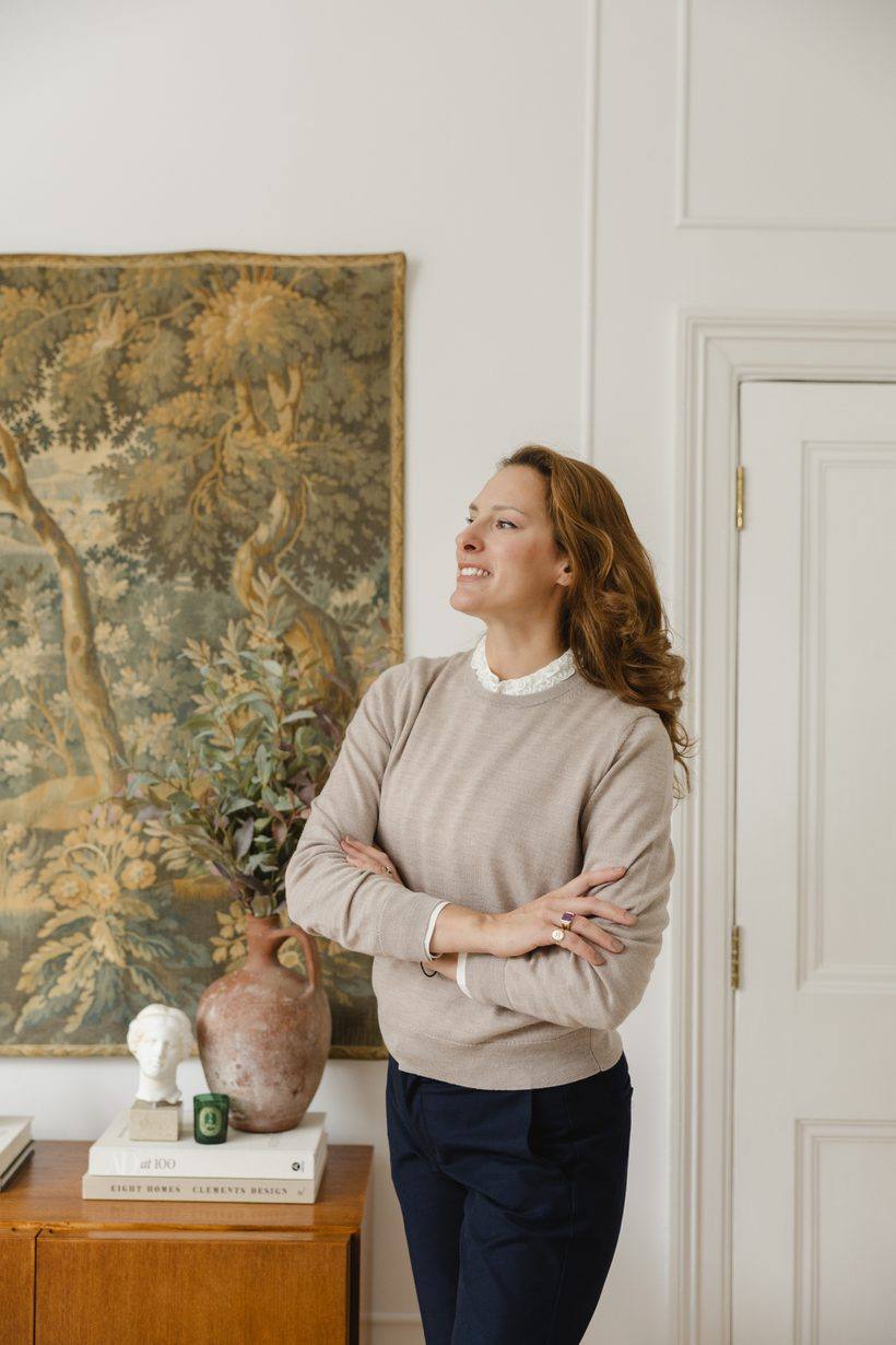 Anastasia Roumelioti standing before a tapestry
